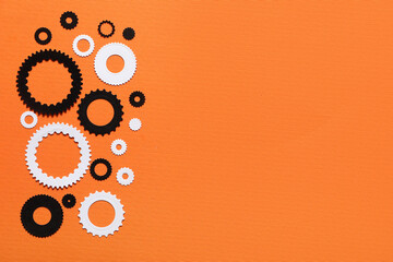 Different paper gears on orange background