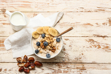 Napkin, bowl with tasty oatmeal, berries and nuts on white wooden background