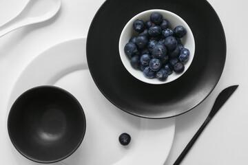 Table setting in white and black colors on light background