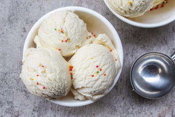vanilla scoop ice cream in a bowl with colorful sprinkles