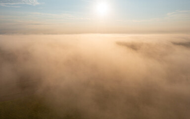 Sunrise foggy scenery at golden hour, drone aerial view