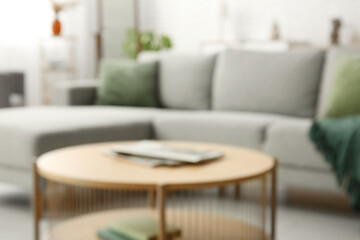 Comfortable sofa and coffee table in interior of living room. Blurred view