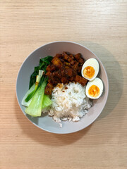 A plate of pork belly, bok choy, eggs, and rice.