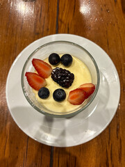 A bowl of panna cotta with berries. 