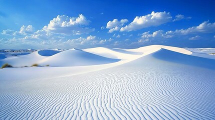 A scenic view of white sand dunes under a bright blue sky with scattered clouds on a sunny day