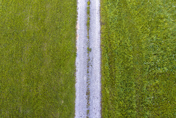 Drone aerial view with green grass fields and countryside road