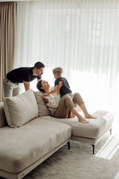 Happy family playing together on comfortable sofa in living room