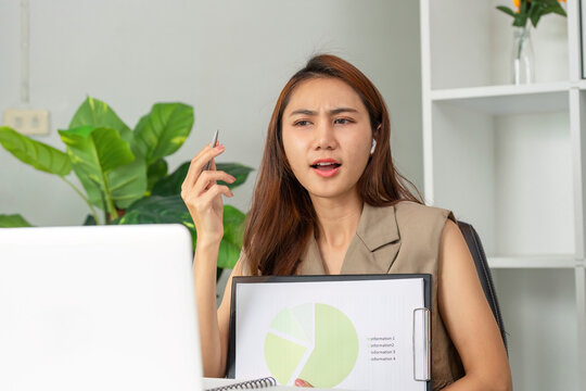 Data Interpretation and Engagement. A young woman presents her findings while using a laptop during a video call.