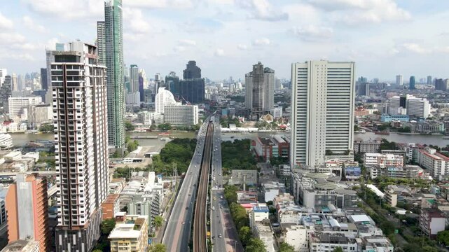 Aerial above Krung Thon Buri Road with Chao Phraya River and Bangkok cityscape