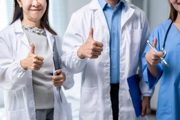 Three doctors are giving thumbs up to each other
