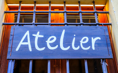 Sign indicating an atelier located in a vibrant neighborhood, showcasing artistic craftsmanship and...