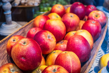 Freshly harvested apples displayed in a rustic basket at a local market during the autumn season with vibrant colors and natural lighting