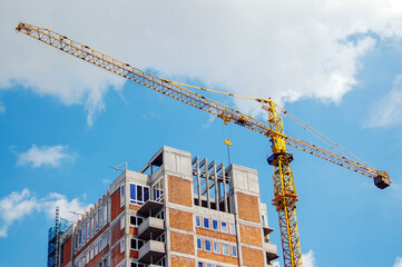 Raw state residential highrise and jib crane over cloudy sky