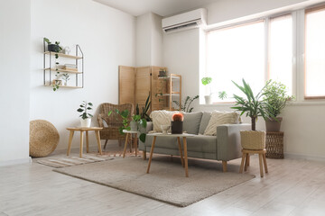 Interior of stylish living room with grey sofa, coffee table and houseplants