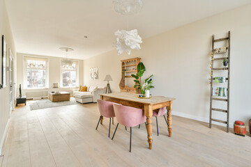 A beautifully designed modern living room featuring minimalistic decor, a wooden table, stylish seating, and warm lighting enhancing the inviting atmosphere.