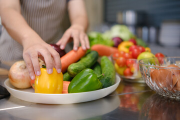 Culinary student standing confidently in training kitchen with fresh ingredients ready for cooking practice