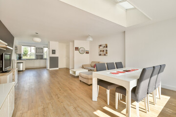 Spacious living area with natural light, featuring stylish furniture and a contemporary dining setup suitable for relaxation and gatherings.