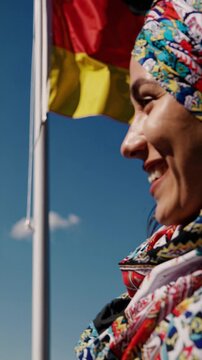 Muslim woman in hijab with German flag, symbol of integration and identity, vertical video, vertical video