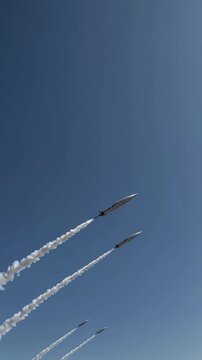 Two missiles flying through sky, vertical video symbol of war and escalation, vertical video