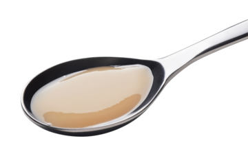 Indulgent close up of condensed milk on spoon highlighting smooth texture and sugary delicious appeal
