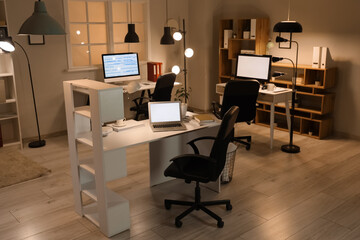 Interior of programmer's office with desks and glowing lamps