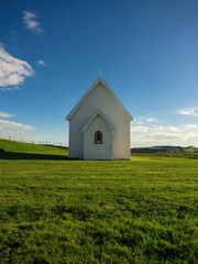 Idyllic iconic rural remote white presbyterian christian chapel Kohekohe Church on green grass meadow on Awhitu Peninsula near Auckland New Zealand