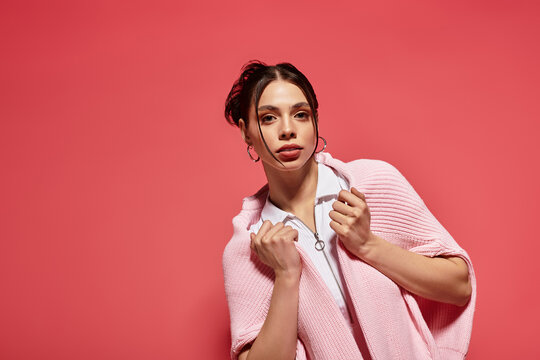 Confident young woman in soft pink outfits against a vibrant backdrop, showing style - Powered by Adobe