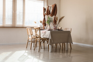 Elegant table setting with beautiful flowers and draped fabric decor in stylish dining room