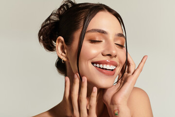 Elegant young woman radiates joy with a bright smile and playful expression in a studio setting