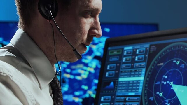 Professional air traffic controller in the control tower. Aircraft control officer works using radar, computer navigation and digital maps. Close-up portrait.
