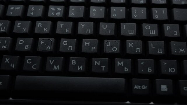 Black computer keyboard with English layout close-up. Wiring to the right. Slow motion. High quality 4k footage