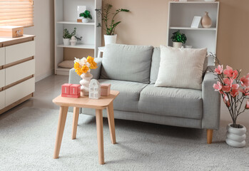 Interior of living room decorated for Mother's Day with sofa, table and shelf units