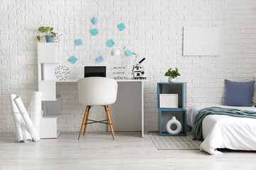 Interior of light teenager's room with bed and workplace