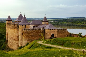 Majestic medieval Khotyn Fortress in Ukraine, with its stone walls and towers, overlooking the green landscape and river. Historical landmark.