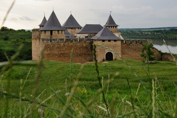 Majestic medieval Khotyn Fortress in Ukraine, with its stone walls and towers, overlooking the green landscape and river. Historical landmark.