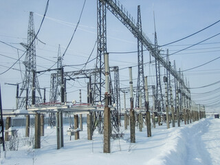 Snowy industrial landscape of electrical substation in winter. Power plant electricity...