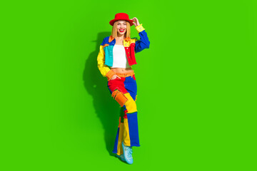 Colorful fashion model posing in vibrant outfit with green background, highlighting creative expression, youthfulness