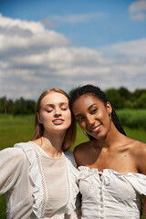 Celebrating love in a sunny meadow with two joyful young women embracing their bond