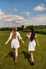 Fototapeta premium Young couple in love explores a beautiful green field on a sunny day together