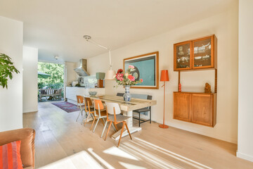 A bright and airy modern dining room featuring a wooden table, chairs, and stylish decor, perfect for gatherings and family meals.