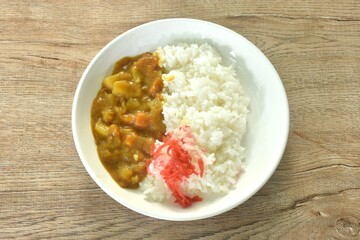 pork with potato and carrot in Japanese curry with rice topping slice red pickled cabbage on plate 