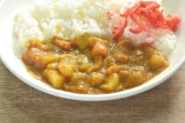 pork with potato and carrot in Japanese curry with rice topping slice red pickled cabbage on plate 