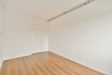 A spacious minimalist room showcasing bare white walls and wooden flooring, ideal for various design inspirations and decoration ideas.