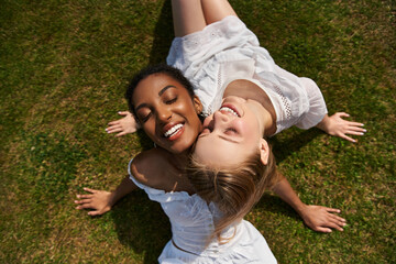 Fototapeta premium Joyful young couple sharing love and laughter on a sunny grass field in the afternoon