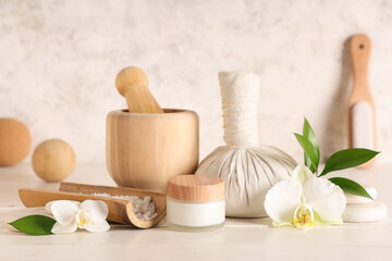 Composition with spa accessories, cosmetic products and orchid flowers on light wooden table