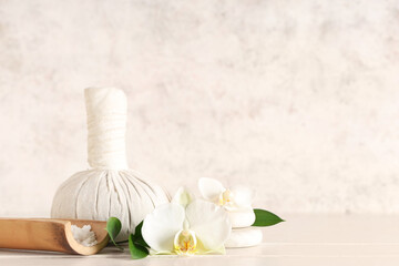 Spa massage bag, sea salt and beautiful orchid flowers on light wooden table
