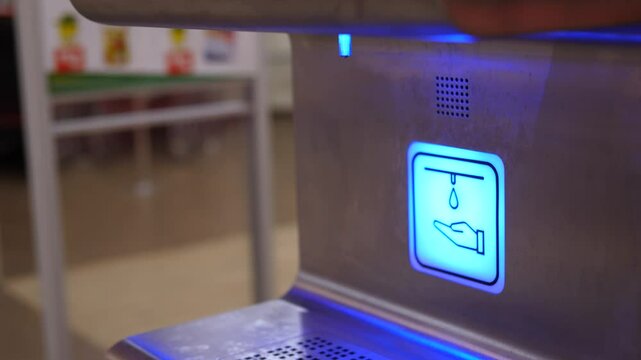 Hygienic hand washing using automatic touchless soap dispenser in public restroom, demonstrating contactless sanitization and health safety protocols