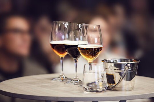 Three Different Sort of Beer in Glasses - Lager, Unfiltered and Stout on table near Spittoon, Close-up