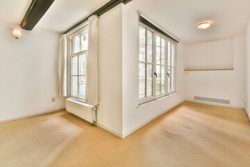 A spacious interior featuring large windows, neutral colors, and a simple design. Perfect for showcasing natural light and minimalist decor.