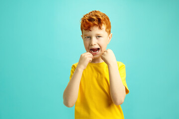 Handsome Little Boy Cleaning His Teeth with a Dental Floss on Blue Isolated. 